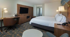 a hotel room with a bed and a desk and a television at Holiday Inn Laval Montreal by IHG in Laval