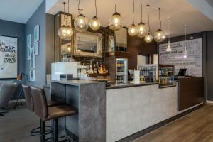 a bar in a restaurant with a counter and chairs at Premier Inn Koblenz City in Koblenz