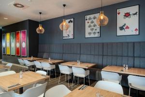 a dining room with wooden tables and white chairs at Premier Inn Koblenz City in Koblenz