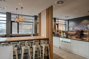 a restaurant with a bar with stools around it at Premier Inn Koblenz City in Koblenz +21 photos