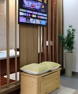 a tv sitting on top of a wooden stand with a stool at Studio Hebron: Refúgio Entre a Cidade e a Natureza in Anápolis