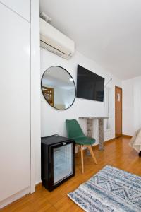 a living room with a mirror and a green chair at Braganca Oporto in Porto