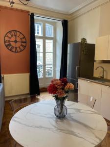 a vase of flowers sitting on a table in a kitchen at Le balcon du Beffroi in Fougères +17 photos