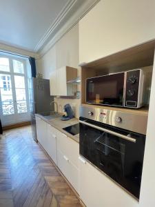 a kitchen with a stove and a microwave at Le balcon du Beffroi in Fougères
