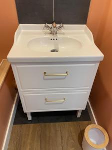 a white sink in a bathroom with a toilet at Le balcon du Beffroi in Fougères