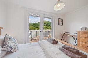 a bedroom with a bed with a window and a desk at Cottage on the Loch in Arrochar