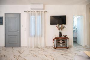 a living room with a door and a vase of flowers at Villa Leta in Kokkari