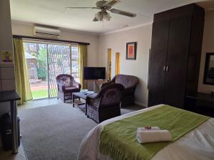 a bedroom with a bed and a living room at Sekelbos Guesthouse in Pretoria +76 photos