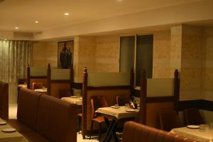 a restaurant with tables and chairs in a room at Rangoli Suites & Restrobar in Bantvāl +31 photos