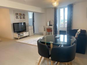 a living room with a glass table and chairs at Les Papillons in Verteillac