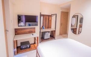 a small bedroom with a bed and a mirror at Indie Stays Studio Kharadi in Pune