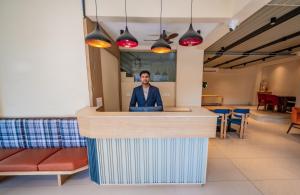 a man standing at a counter in a restaurant at Indie Stays Studio Kharadi in Pune