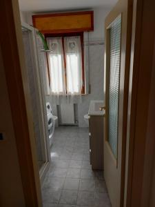a bathroom with a toilet and a sink and a window at Flat in Chiesina Uzzanese in Chiesina Uzzanese