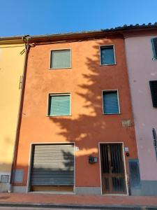 a orange building with a tree shadow on it at Flat in Chiesina Uzzanese in Chiesina Uzzanese