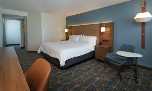 a hotel room with a bed and a table and a chair at Holiday Inn Laval Montreal by IHG in Laval