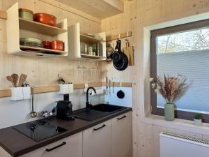 a kitchen with a sink and a window at SeeLaVie - Tiny Houses am Mattsee in Mattsee +24 photos