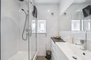 a white bathroom with a shower and a sink at Cottage on the Loch in Arrochar +26 photos