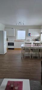 a kitchen with a table and chairs and a refrigerator at Solbakken 27 Apartment in Lyngseidet