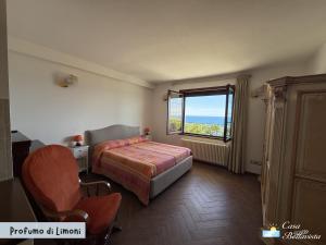 a bedroom with a bed and a window and a chair at Casa Bellavista in Bergeggi