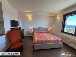 a bedroom with a bed and a chair and a window at Casa Bellavista in Bergeggi