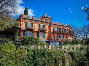 a large orange house on top of a hill at Hotel Castello S. Antonio in Lazise