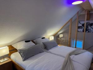 a bedroom with two beds with white sheets and pillows at TinyLoft in Bad Teinach-Zavelstein