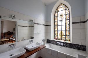 a bathroom with two sinks and a stained glass window at Villa l'Orante in Lourdes