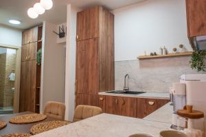 a kitchen with wooden cabinets and a table with chairs at Forestline Apartment Sinaia in Sinaia +20 photos