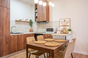 a kitchen with a table with chairs and a microwave at Forestline Apartment Sinaia in Sinaia
