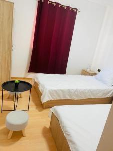 a room with two beds and a table and a chair at Camping La Ozan in Petreştii de Jos