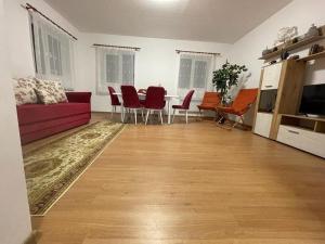 a living room with a red couch and a table at Camping La Ozan in Petreştii de Jos +10 photos