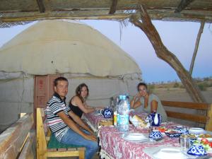 a group of people sitting at a table in a tent at Aydar Eco Yurt Camp in Ingichka