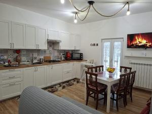a kitchen with white cabinets and a table with chairs at La Dimora delle Fate - SOFIA in Bagnoli Irpino