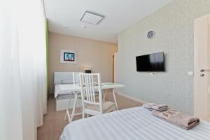 ウラン・ウデにあるOrda Hotelのベッド、テーブル、テレビが備わる客室です。