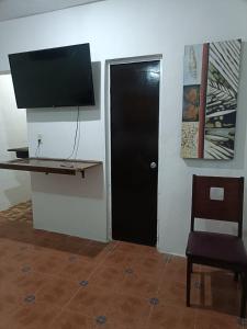 a room with a black door and a television at Casa Albino in Izamal
