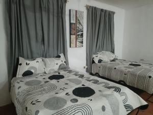 a bedroom with two beds and curtains at Casa Albino in Izamal