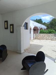 a room with two chairs and a view of a building at Casa Albino in Izamal
