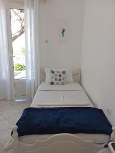 a white bed in a room with a window at Konstantinos in Chorto