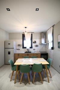 a kitchen with a table and four green chairs at Julis Villa in Draç