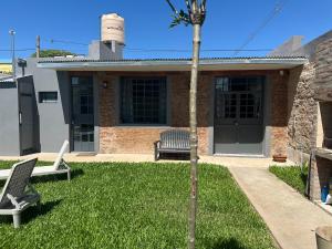 a house with two chairs and a palm tree in the yard at Apartamento El Rancho in San Pedro