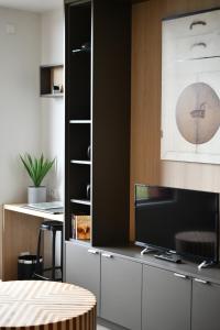 a living room with a tv on a cabinet at Les Appartements du Vignoble in Kientzheim