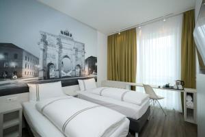 two beds in a room with a picture of a building at Premier Inn München City West in Munich