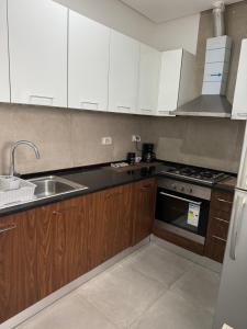 a kitchen with wooden cabinets and a sink and a stove at Le Chill Out in Tunis