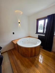 a large wooden tub in a room with a window at Hotel Surprise Bariloche Centro con Desayuno y Restaurante in San Carlos de Bariloche +38 photos