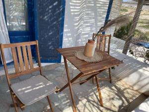a wooden table and a chair on a porch at Dejableu - Island Living Paros in Sarakíniko