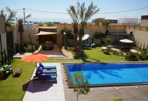an overhead view of a pool with chairs and an umbrella at Atlantis The Palm Villa 2 in Al Rama