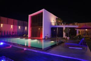 a swimming pool in front of a house at night at Atlantis The Palm Villa 2 in Al Rama +3 photos