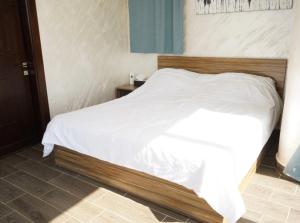 a bedroom with a white bed with a wooden headboard at Atlantis The Palm Villa 2 in Al Rama