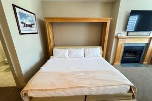 a large bed in a room with a fireplace at Long Trail House 459 in Stratton