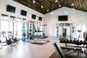 a gym with several treadmills and exercise machines at Azalea & Blackberry Cabins in Jasper